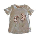 Girls oatmeal coloured t-shirt with a graphic of two platypus blowing bubbles on a white background